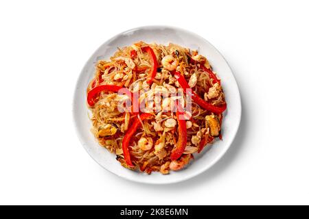Spaghetti di riso speziati con gamberetti fritti, cozze, calamari e verdure sul piatto Foto Stock