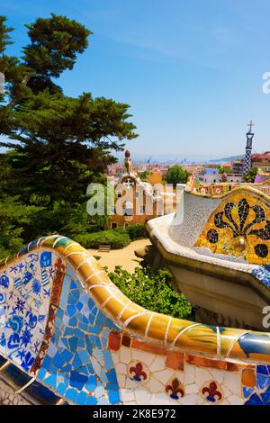 Barcellona. Panca in ceramica e edifici del Parco Guell progettati dal famoso architetto Antoni Gaudi (1852-1926). UNESCO, Sito Patrimonio Mondiale dell'Umanità. Foto Stock