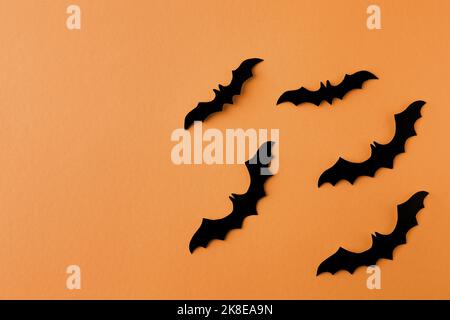 Concetto di Halloween. Pipistrelli neri su sfondo arancione Foto Stock