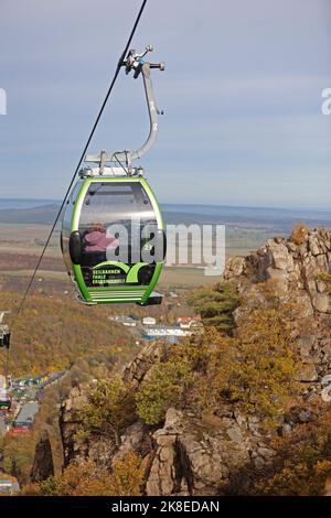 Thale, Germania. 23rd Ott 2022. Le gondole della funivia galleggiano sopra la Valle del Bode. Il tempo soleggiato ha attirato molti visitatori sulle montagne Harz. Gli operatori delle funivie e degli impianti di risalita di Harz stanno vivendo un elevato numero di visitatori questo fine settimana con l'inizio delle vacanze autunnali. Credit: Matthias Bein/dpa/Alamy Live News Foto Stock