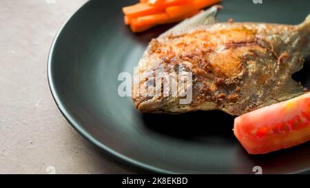 Pesce pomfret o ikan Bawal, che sono stati cotti o fryied bene Foto Stock