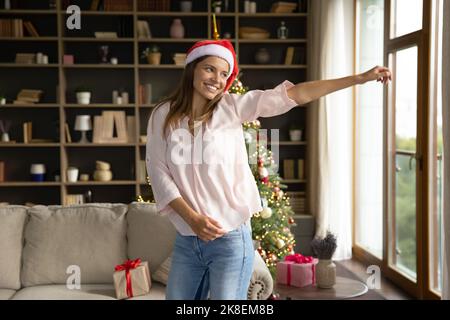 Felice giovane donna in atmosfera festosa ballando alla musica di Natale. Foto Stock