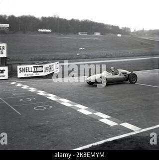 1959, storico, corse automobilistiche, Cooper Driving School, un pilota di corse in una monoposto aperta, una Formula Cooper Junior, corse sul circuito di Brands Hatch, Kent, Inghilterra, UK. Un nome leggendario nello sport motoristico, Coopers ha raggiunto il livello più alto diventando campione mondiale costruttore di Formula uno nel 1959 e 1960, i primi vincitori in assoluto in un'auto con motore posteriore. A quel tempo, la Cooper Car Company, con sede in Gran Bretagna, era il più grande produttore specializzato al mondo di auto da corsa e la loro "Mini Cooper" ha fatto da guida nel rallying. Foto Stock