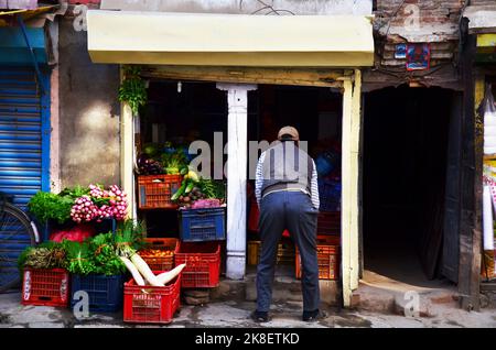 Gli uomini nepalesi vendono varietà di verdure e frutta in bancarella negozio biologico e negozio di alimentari nel mercato bazaar città vecchia per la gente nepalese selezionare acquistare cibo co Foto Stock