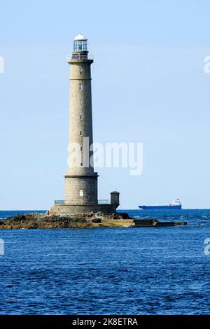 Frankreich, la Hague, 20.09.2022: Der Leuchtturm von Goury und ein Frachtschiff am Cap de la Hague vor der Halbinsel Cotentin an der franzoesischen Ka Foto Stock