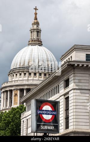 Londra, Regno Unito - 5 giugno 2017: La cupola della cattedrale di St Paul dietro un cartello della metropolitana di Londra. Concentrati sull'iconico logo del tubo rosso, bianco e blu Foto Stock