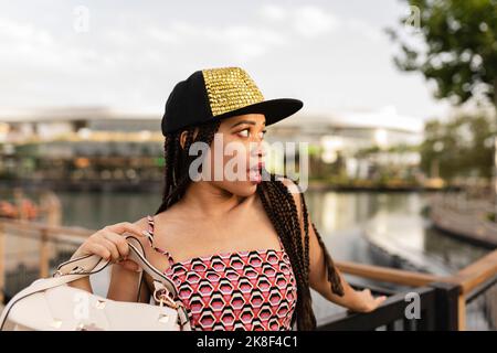 Giovane donna con capelli lunghi intrecciati che indossa la cuffia Foto Stock