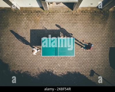 Uomo con figlia che gioca a ping pong nel cortile posteriore Foto Stock