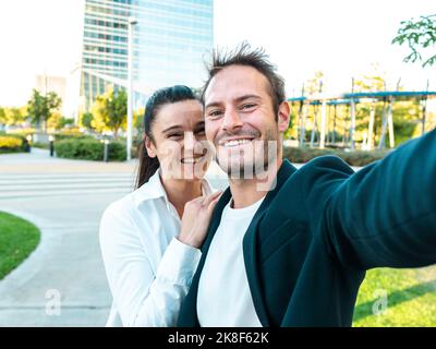 Felice donna d'affari con un collega che prende selfie al parcheggio dell'ufficio Foto Stock