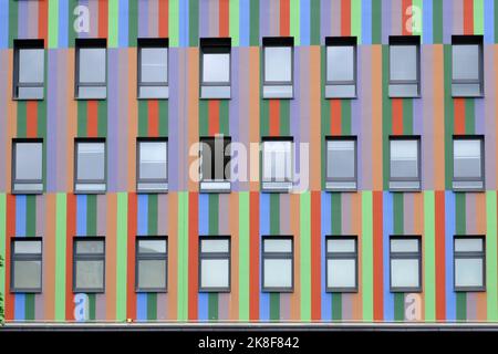 File di finestre di colorato edificio a strisce Foto Stock