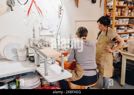 Imprenditore con collega che lavora in laboratorio di ceramica Foto Stock