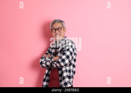 Il 40s adulto asiatico uomo stnading su sfondo rosa con abiti casual. Foto Stock