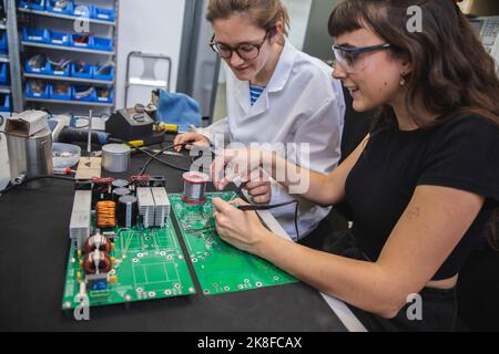 Ingegneri che saldano insieme i circuiti stampati nell'industria elettronica Foto Stock