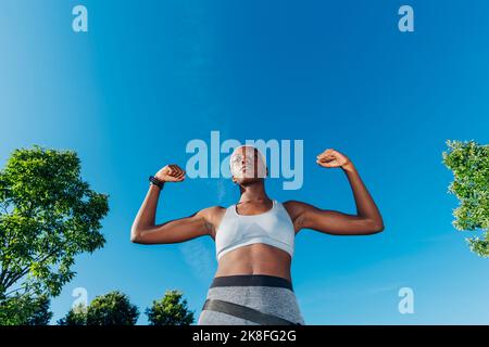 Muscoli sportivi sicuri che flettono nelle giornate di sole Foto Stock