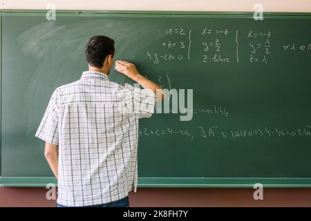 L'insegnante cancella le formule matematiche sulla lavagna Foto Stock