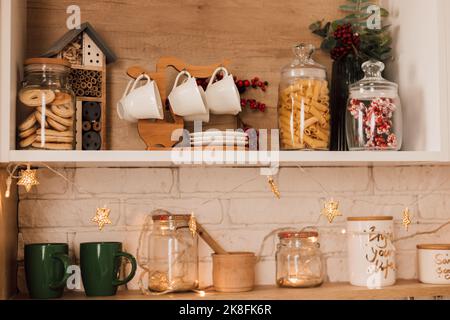 Interno cucina decorato con ghirlande di Natale e alberi di Natale Foto Stock