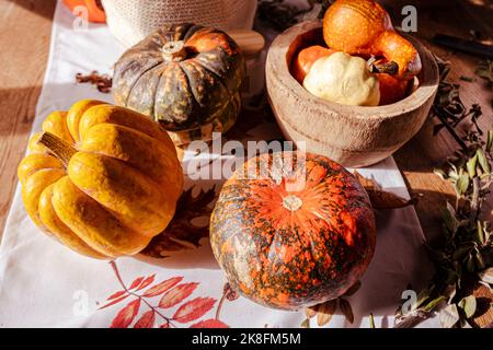 Vibrazioni autunnali con zucche colorate e zucche su un tavolo Foto Stock