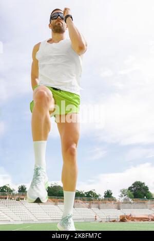 Sportivo che pratica la corsa sul campo sportivo Foto Stock
