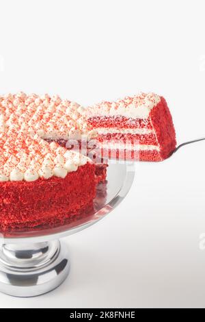 Fetta di torta di velluto rosso fresco su pala per torta su sfondo bianco Foto Stock