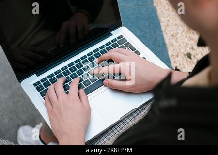 Mani di giovani studenti che utilizzano il notebook a parete Foto Stock