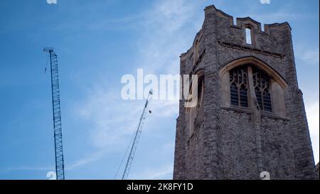 Una vista della chiesa di Acton Hill e una gru per lo sviluppo contrastato sullo sfondo. Foto Stock