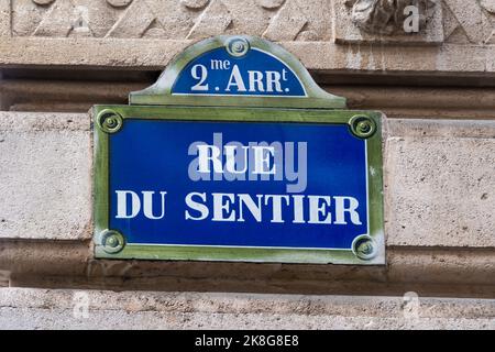 Tradizionale cartello di strada parigino con scritta 'Rue du Sentier', situato nella zona specializzata nell'industria tessile a Parigi, Francia Foto Stock