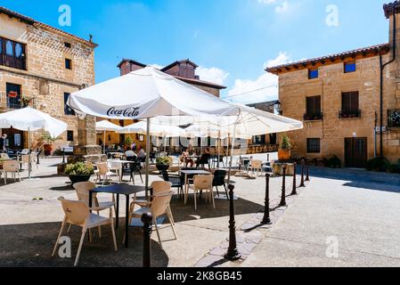 Ombrelloni sulla terrazza di un bar nella piazza del municipio. Strada di Sajazarra. Villaggio medievale a la Rioja alta. Sajazarra, la Rioja, Spagna, EUR Foto Stock