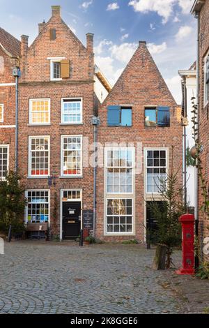 Case antiche strette con persiane su una piccola piazza nel centro della città medievale olandese di Deventer. Foto Stock