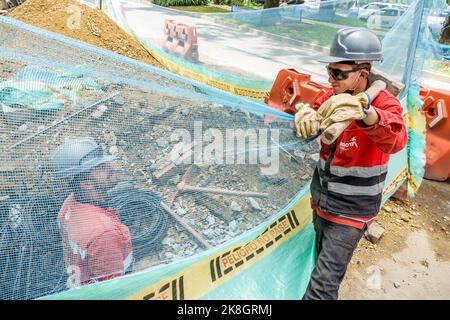 Bogota Colombia, El Chico Calle 94, sotto il nuovo sito di costruzione indossare elmetto cappelli capitale miglioramenti mesh barriera città elettrica acqua utilità, uomo Foto Stock
