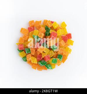 cumulo di pezzi di frutta candita primo piano isolato su fondo bianco, ananas secchi dolci, arance e papaya in sciroppo di zucchero, utilizzato come ripieno in con Foto Stock