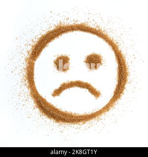 la vista dall'alto dello zucchero di canna naturale non raffinato si presenta sotto forma di tristi emoticon isolati su sfondo bianco, zucchero di canna Foto Stock