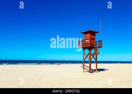 Torre del bagnino in legno rosso a Playa de la Barrosa, Cadice, Spagna Foto Stock