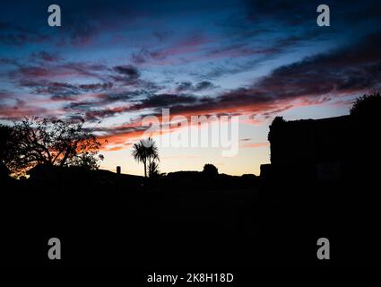 Devon Skys in Autumn. The sun sets over the village. Foto Stock