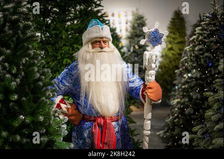 Russo Babbo Natale con uno staff in un negozio di alberi artificiali di Natale. Foto Stock