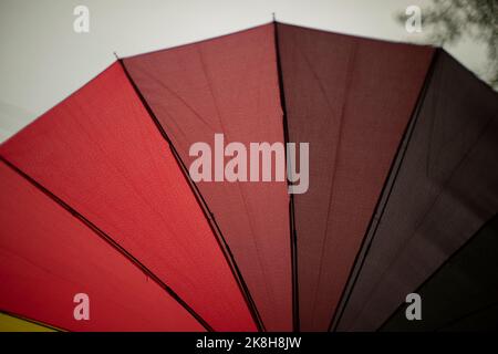 Ombrello rosso dalla pioggia. Gradiente rosso. Aghi per ombrello e tessuto. Dettagli articolo. Foto Stock