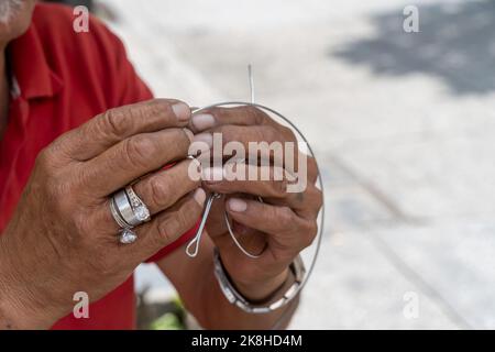 artigiano sulla strada facendo figurine di bicicletta con filo, figurine di metallo fatte a mano messico Foto Stock