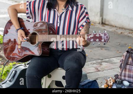 latina donna che suona la chitarra per strada, giovane bruna donna, america latina Foto Stock