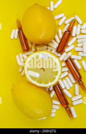 Flying vitamina C pillole e limoni taglio impostato su un sfondo giallo.Lots di pillole e agrumi..frutta naturale Vitamina C.Immunity rimedio. Foto Stock