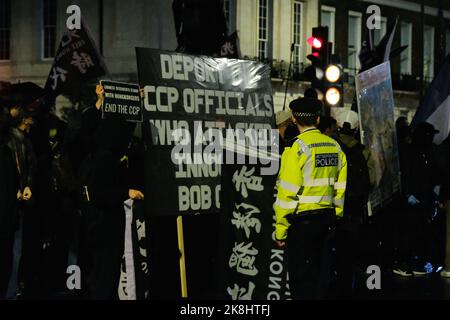 Londra, Regno Unito. 23rd ottobre 2022. Centinaia di Hong-Kongers britannici, tibetani e uiguri si sono riuniti a Whitehall e hanno marciato contro l'ambasciata cinese per protestare contro l'assalto di Hong Konger Bob Chan, che si dice abbia avuto luogo durante un raduno a favore della democrazia la scorsa settimana. Chan dice di essere stato trascinato nei terreni del Consolato cinese di Manchester e picchiato, poco dopo che il personale è emerso e afferrato manifesti dimostranti ha messo fuori dai cancelli. Credit: Undicesima ora di Fotografia/Alamy Live News Foto Stock