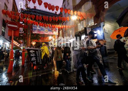 Londra, Regno Unito. 23rd Ott 2022. I manifestanti tengono gli ombrelli mentre una tempesta di pioggia si riversa quando arrivano a China Town a Londra, in Gran Bretagna, il 23 ottobre 2022.centinaia di persone si riuniscono a Downing Street'', Poi''‹ marcia all'ambasciata cinese via Chinatown sotto un improvviso temporale a Londra, per protestare contro l'incidente d'assalto in cui un protesico di Hong Kong Bob Chan, che è stato visto essere tirato nei terreni di un consolato cinese a Manchester e picchiato dal personale il 17 ottobre 2022. (Credit Image: © May James/ZUMA Press Wire) Credit: ZUMA Press, Inc./Alamy Live News Foto Stock