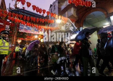 Londra, Regno Unito. 23rd Ott 2022. I manifestanti tengono gli ombrelli mentre una tempesta di pioggia si riversa quando arrivano a China Town a Londra, in Gran Bretagna, il 23 ottobre 2022.centinaia di persone si riuniscono a Downing Street'', Poi''‹ marcia all'ambasciata cinese via Chinatown sotto un improvviso temporale a Londra, per protestare contro l'incidente d'assalto in cui un protesico di Hong Kong Bob Chan, che è stato visto essere tirato nei terreni di un consolato cinese a Manchester e picchiato dal personale il 17 ottobre 2022. (Credit Image: © May James/ZUMA Press Wire) Credit: ZUMA Press, Inc./Alamy Live News Foto Stock