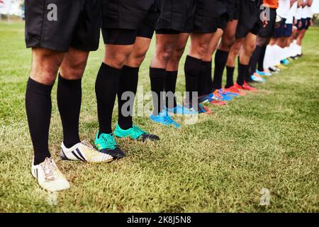 Un gruppo di giocatori di rugby che si trovano in una linea sul campo. Foto Stock