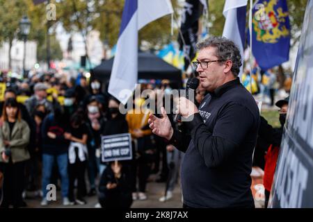 Benedetto Rogers, co-fondatore e Chief Executive di Hong Kong Watch, parla durante un'assemblea del Partito comunista anti-cinese di fronte a downing Street a Londra. Centinaia di persone hanno marciato sotto una tempesta di pioggia da Downing Street attraverso Chinatown all'ambasciata cinese a Londra, per protestare contro l'incidente d'assalto in cui Bob Chan, un protestante di Hong Kong, Che è stato visto essere tirato nei terreni di un consolato cinese a Manchester e picchiato dal personale il 17 ottobre 2022. Centinaia di persone hanno marciato sotto una tempesta di pioggia da Downing Street via Chinatown all'ambasciata cinese a Londra per protestare contro ag Foto Stock