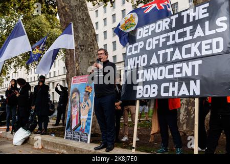 Benedict Rogers (C), co-fondatore e Chief Executive di Hong Kong Watch, parla durante un'assemblea del Partito Comunista anti-cinese di fronte a downing Street a Londra. Centinaia di persone hanno marciato sotto una tempesta di pioggia da Downing Street attraverso Chinatown all'ambasciata cinese a Londra, per protestare contro l'incidente d'assalto in cui Bob Chan, un protestante di Hong Kong, Che è stato visto essere tirato nei terreni di un consolato cinese a Manchester e picchiato dal personale il 17 ottobre 2022. Centinaia di persone hanno marciato sotto una tempesta di pioggia da Downing Street attraverso Chinatown all'ambasciata cinese a Londra fino ai protes Foto Stock