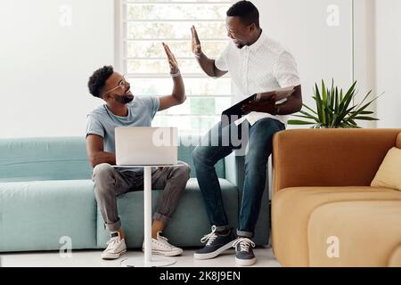 Grazie per l'aiuto. Scatto completo di due bei uomini d'affari che si danno un alto cinque mentre lavorano insieme nell'ufficio. Foto Stock