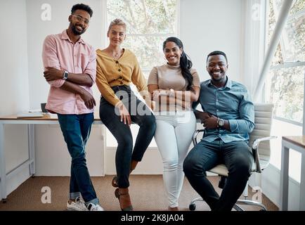 Un altro giorno per crescere nel business. Ritratto ritagliato di un gruppo di uomini d'affari diversi seduti insieme dopo una discussione di successo in ufficio. Foto Stock