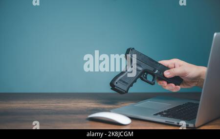 Pistola d'acquisto dal negozio del venditore in linea, mani del venditore che trasmette la pistola sul calcolatore alla persona d'acquisto della pistola sul Web site o sui mezzi sociali con la copia spac Foto Stock