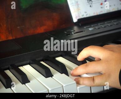 Una mano pianista che suona il pianoforte. Le dita di qualcuno che prende lezione di pianoforte. Foto Stock