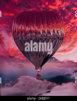 Splendide mongolfiere sul cielo rosso al tramonto Foto Stock
