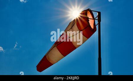 Calzino per vento. Bandiera Windsock. Indicatore di direzione del vento. Intensità del vento. Windsock di fronte al cielo blu. Foto Stock